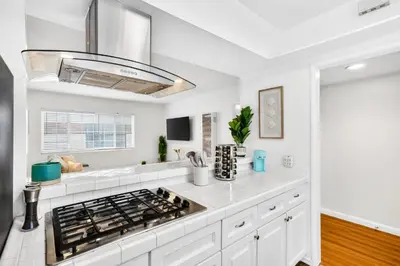 a kitchen with white cabinets and a stove top oven at Prime Manhattan Beach 2BR Walk to Beach with Parking in Manhattan Beach