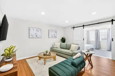 a living room with a green couch and a table at Prime Manhattan Beach 2BR Walk to Beach with Parking in Manhattan Beach