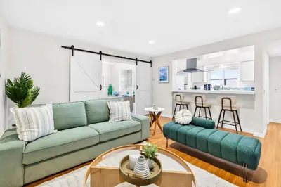 a living room with a green couch and a table at Prime Manhattan Beach 2BR Walk to Beach with Parking in Manhattan Beach