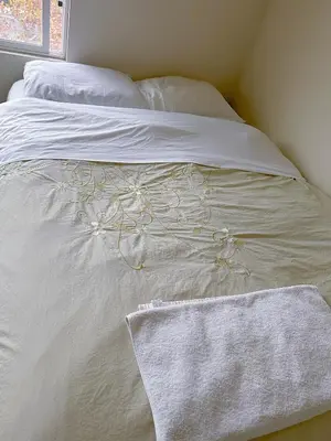 a white bed with white sheets and a towel on it at Big quiet bedroom in Hacienda Heights