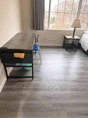 a room with a wooden table and a room with a bed at Big bedroom shared bathroom in Fontana