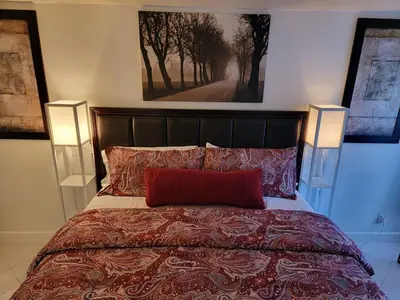 a bedroom with a bed with a red pillow and two lights at A Tranquil Retreat in Tarzana CA in Tarzana