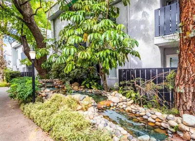 a garden with a pond in front of a house at A Tranquil Retreat in Tarzana CA in Tarzana