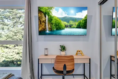 a room with a desk with a waterfall painting on the wall at Brand New 2BR Loft near Universal & Hollywood in Los Angeles