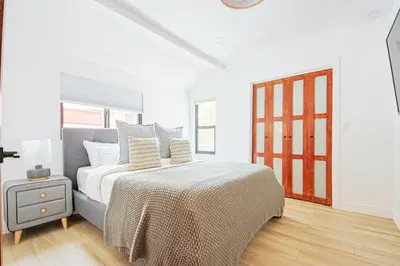 a white bedroom with a bed and a window at 2 Units Oasis Villa w terrace&roofdeck 12 pax in Los Angeles