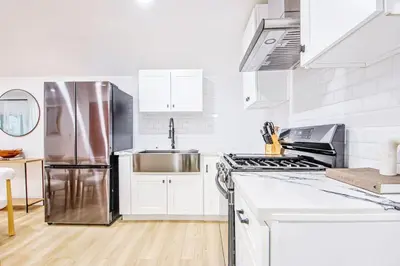 a kitchen with white cabinets and a stainless steel refrigerator at 2 Units Oasis Villa w terrace&roofdeck 12 pax in Los Angeles