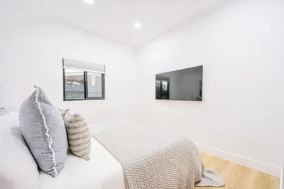 a white bedroom with a bed and two mirrors at 2 Units Oasis Villa w terrace&roofdeck 12 pax in Los Angeles