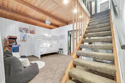 a living room with a staircase in a house at Arrowbear Retreat - EV Charging, Generator, Arcade in Arrowbear Lake