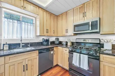 a kitchen with stainless steel appliances and wooden cabinets at Arrowbear Retreat - EV Charging, Generator, Arcade in Arrowbear Lake