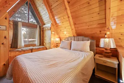 a bedroom with a bed in a log cabin at The Highpoint - Close to Lake/Village, Fireplace, Smart TV, Hammock, BBQ in Big Bear Lake
