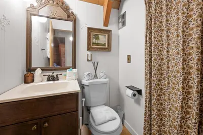 a bathroom with a toilet and a sink and a mirror at The Highpoint - Close to Lake/Village, Fireplace, Smart TV, Hammock, BBQ in Big Bear Lake