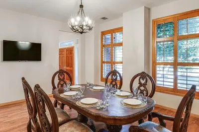 a dining room with a table and chairs and a television at Games Galore! Pine Mountain Club Retreat Near Town in Pine Mountain Club