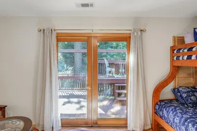 a bedroom with a sliding glass door with a balcony at Games Galore! Pine Mountain Club Retreat Near Town in Pine Mountain Club
