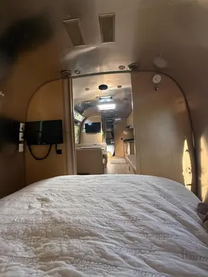 a large white bed in a room with a mirror at Airstream at Tree Ranch Grove Paradise in Ojai