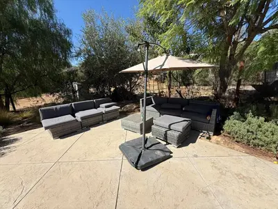 a patio with a couch and an umbrella at Airstream at Tree Ranch Grove Paradise in Ojai
