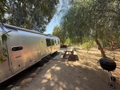 a white trailer parked in the shade of a tree at Airstream at Tree Ranch Grove Paradise in Ojai