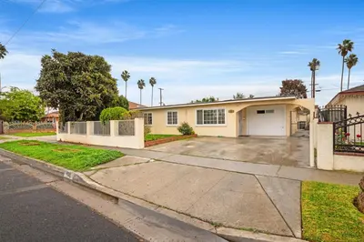 a house with a driveway and palm trees at Fireplace Evenings • Smart TV • Sleeps 7 in Carson