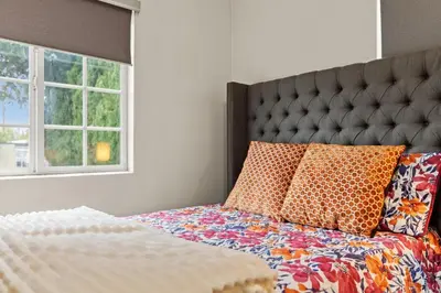 a bedroom with a bed with a large headboard and pillows at Fireplace Evenings • Smart TV • Sleeps 7 in Carson