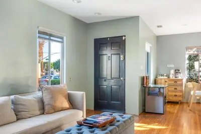 a living room with a couch and a black door at 5 STAR BEAUTIFUL LONG BEACH HOuSE in Long Beach