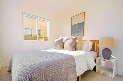 a bedroom with a large bed with white sheets and a window at Relaxing 4BR LA Home Private Pool & Fire Pit in Los Angeles