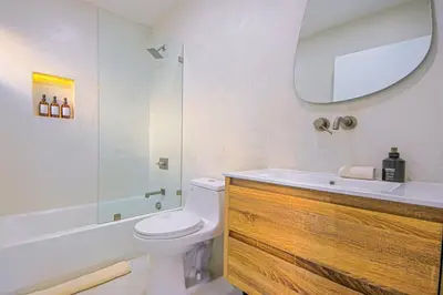 a bathroom with a toilet and a sink and a mirror at Relaxing 4BR LA Home Private Pool & Fire Pit in Los Angeles