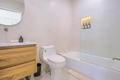 a bathroom with a toilet and a tub and a sink at Relaxing 4BR LA Home Private Pool & Fire Pit in Los Angeles