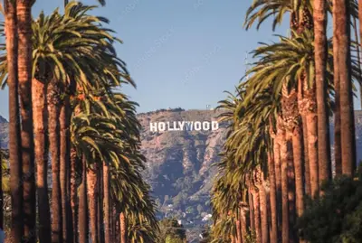 a view of the hollywood sign through palm trees at Polished 1BR Hollywood Apt w Rooftop Pool & Views in Los Angeles