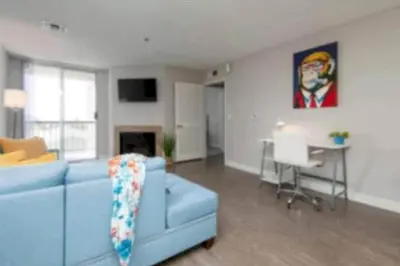a living room with a blue couch and a table at Polished 1BR Hollywood Apt w Rooftop Pool & Views in Los Angeles