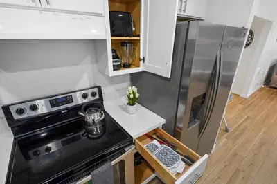 a kitchen with a stove and a stainless steel refrigerator at Walk to Shoreline Village, BBQ in Prime Location in Long Beach