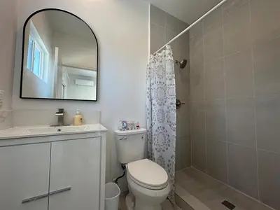 a bathroom with a toilet and a sink and a mirror at Brand New Muji Style 3B3B Retreat with Courtyard in Walnut