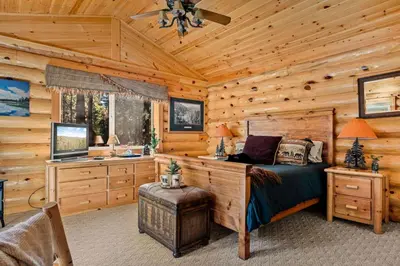 a bedroom with a bed in a log cabin at Honeycomb Hideaway in Big Bear Lake