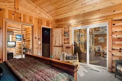 a bedroom with a bed in a log cabin at Honeycomb Hideaway in Big Bear Lake