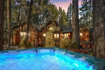 a log cabin in the woods with a swimming pool at Honeycomb Hideaway in Big Bear Lake
