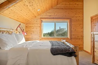 a bedroom with a bed in a wooden cabin at Hawk Ridge Chalet In Big Bear Lake in Big Bear Lake