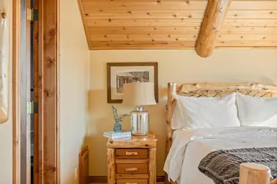 a bedroom with a bed and a lamp on a night stand at Hawk Ridge Chalet In Big Bear Lake in Big Bear Lake