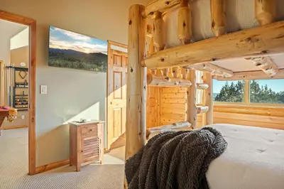 a bedroom with a bunk bed in a log cabin at Hawk Ridge Chalet In Big Bear Lake in Big Bear Lake
