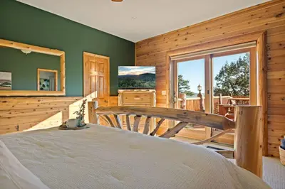 a bedroom with a bed and a large window at Hawk Ridge Chalet In Big Bear Lake in Big Bear Lake