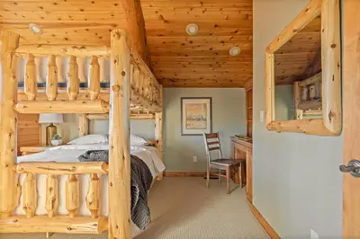 a log cabin bedroom with a bunk bed and a desk at Hawk Ridge Chalet In Big Bear Lake in Big Bear Lake