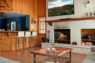 a living room with a fireplace and a tv at Solstice Shores Chalet, Hot Tub and Lake Views in Fawnskin