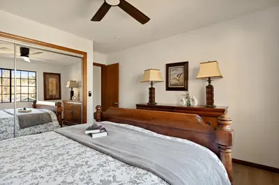 a bedroom with a large bed and a mirror at Solstice Shores Chalet, Hot Tub and Lake Views in Fawnskin