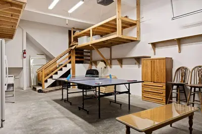 a ping pong table in a room with a staircase at Solstice Shores Chalet, Hot Tub and Lake Views in Fawnskin