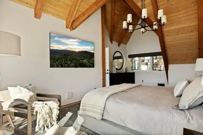 a bedroom with a large bed and a chandelier at Seuss by the Shore in Big Bear Lake