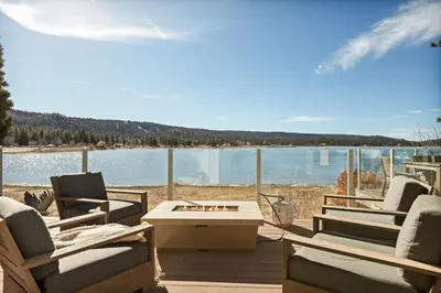 a patio with chairs and a table and a view of the water at Seuss by the Shore in Big Bear Lake