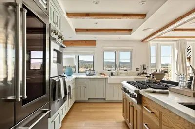 a kitchen with white cabinets and a stove top oven at Seuss by the Shore in Big Bear Lake
