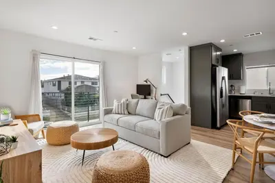 a living room with a couch and a kitchen at Luxe 3BR South Bay - Comfort and Close to Beach in Harbor City