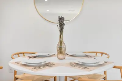 a table with plates and a vase with a mirror at Luxe 3BR South Bay - Comfort and Close to Beach in Harbor City
