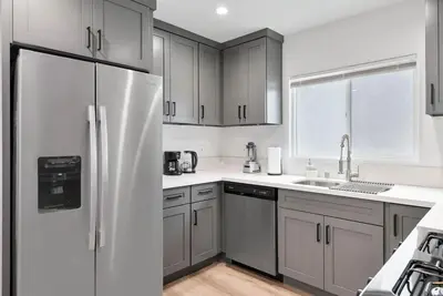 a kitchen with white cabinets and a refrigerator at Luxe 3BR South Bay - Comfort and Close to Beach in Harbor City