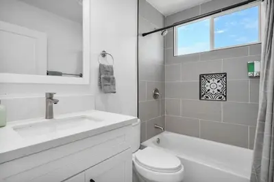 a white bathroom with a sink and a toilet and a window at Luxe 3BR South Bay - Comfort and Close to Beach in Harbor City