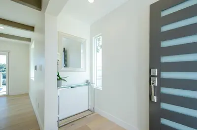 a hallway with a white door and a mirror at Beautiful home with VIEWS in Silver Lake Hills in Los Angeles