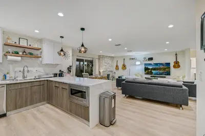 a kitchen and living room with a couch and a table at 20 min to Disneyland - Spacious Family Home Near All the Fun in Westminster